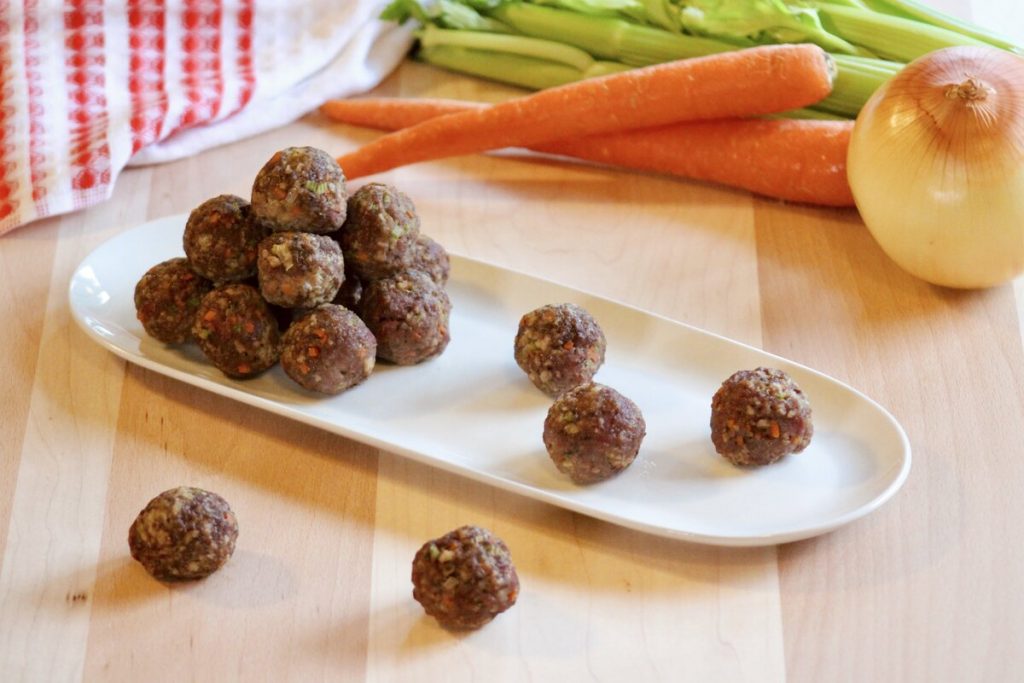 plate with meatballs and vegetables on a wood tray