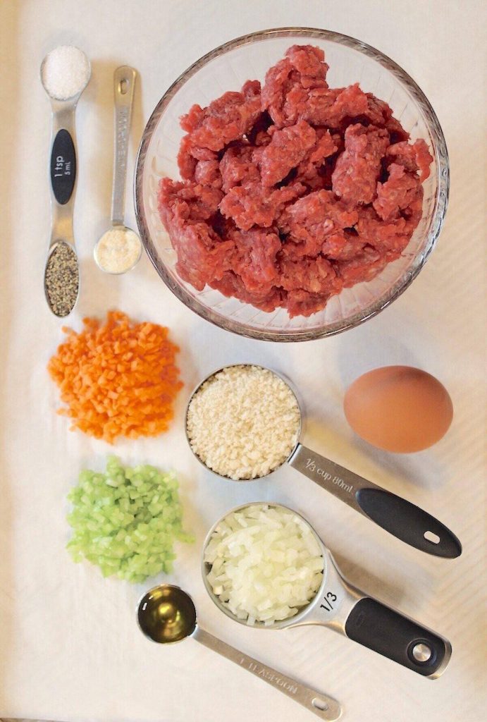 all the ingredients for the meatballs measured out on a white board