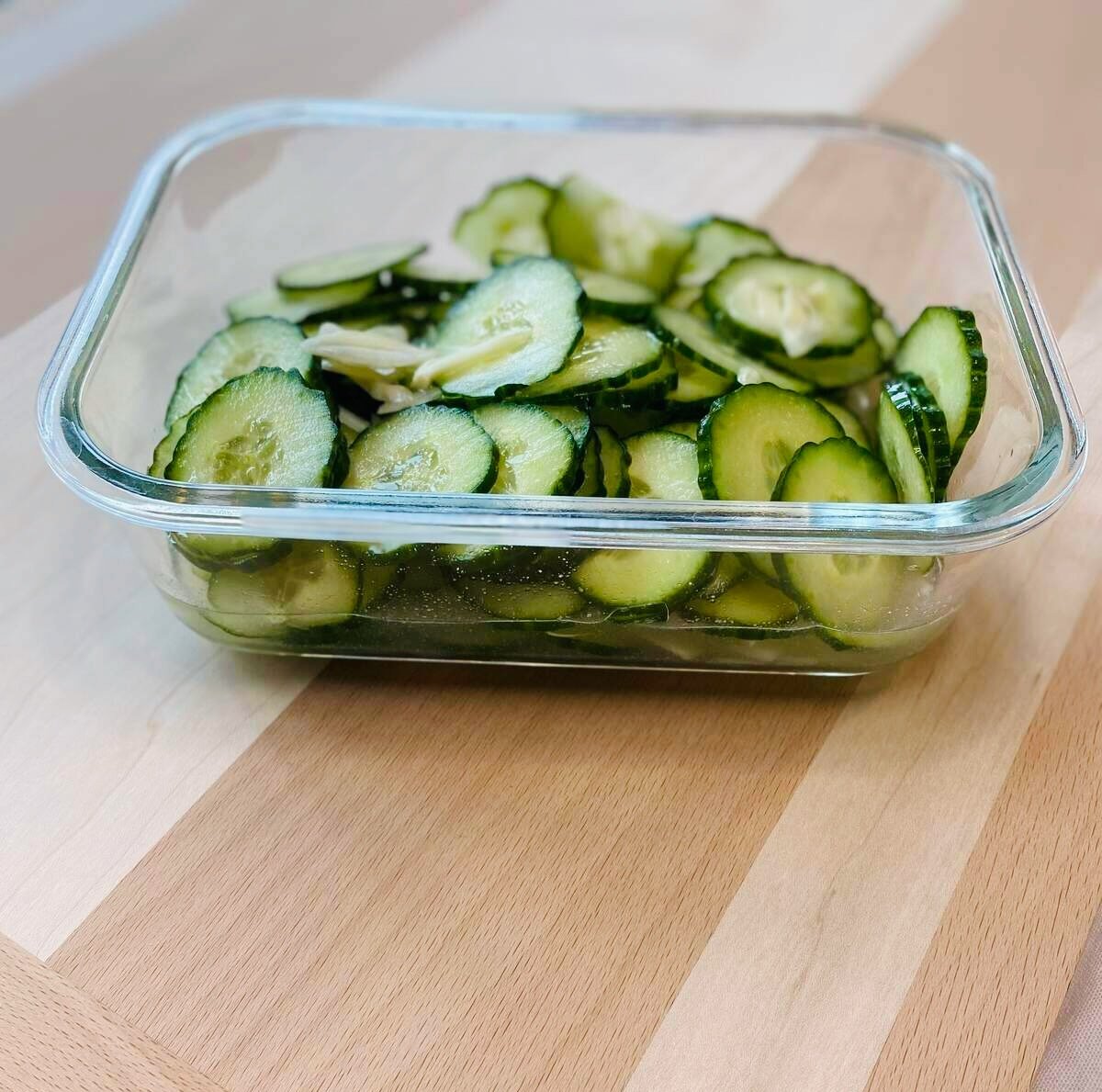 Marinated cucumbers in a glass dish.