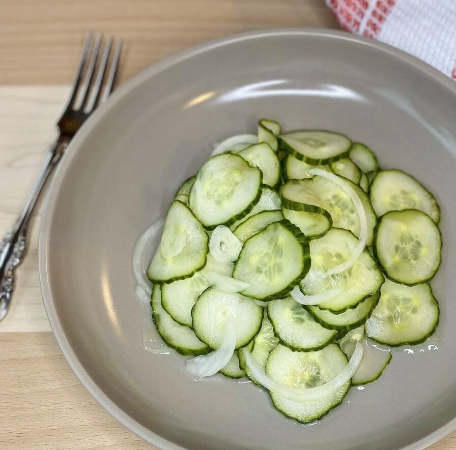 A close up of bowl of marinated cucumbers.