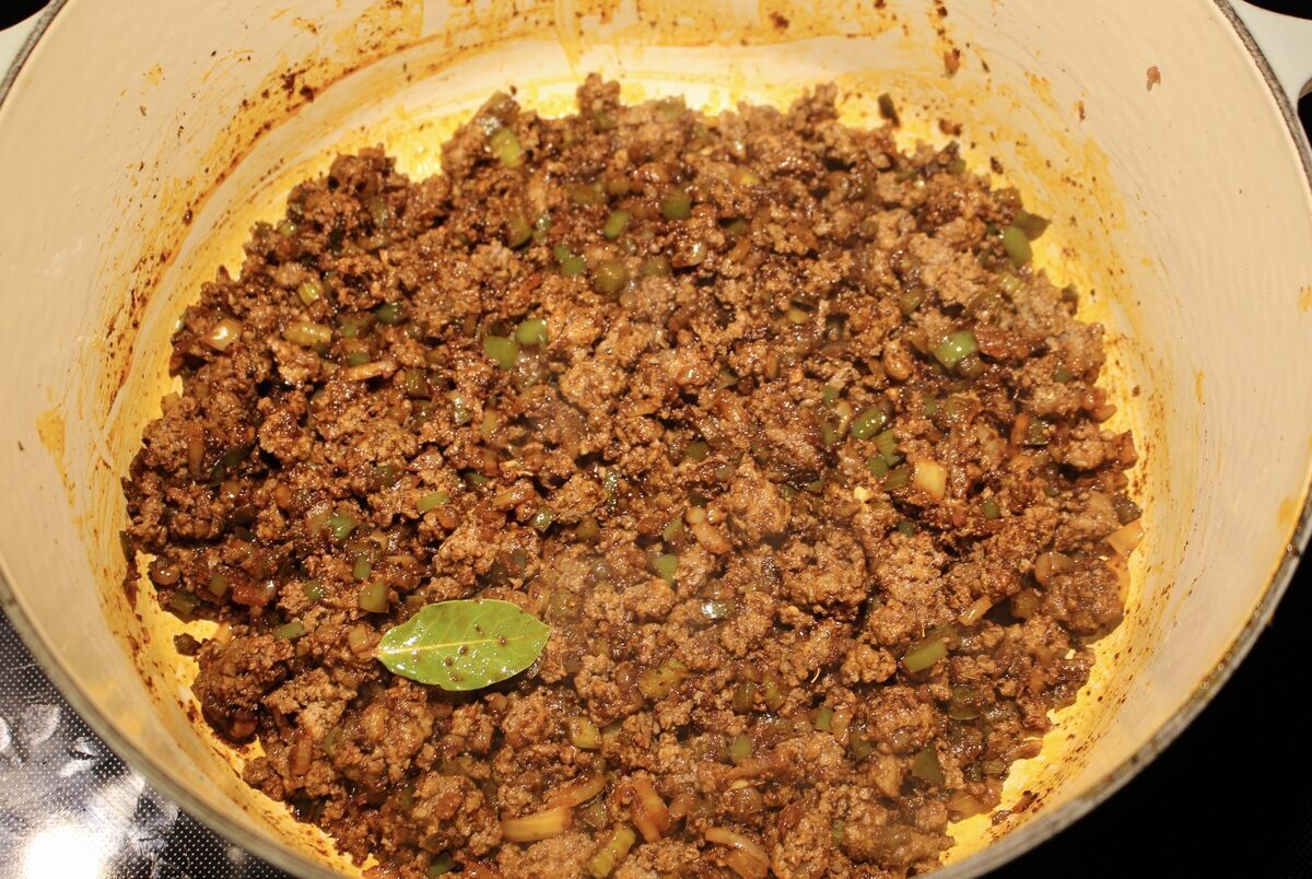 Chili vegetables, seasonings and beef sauteeing in a pot.