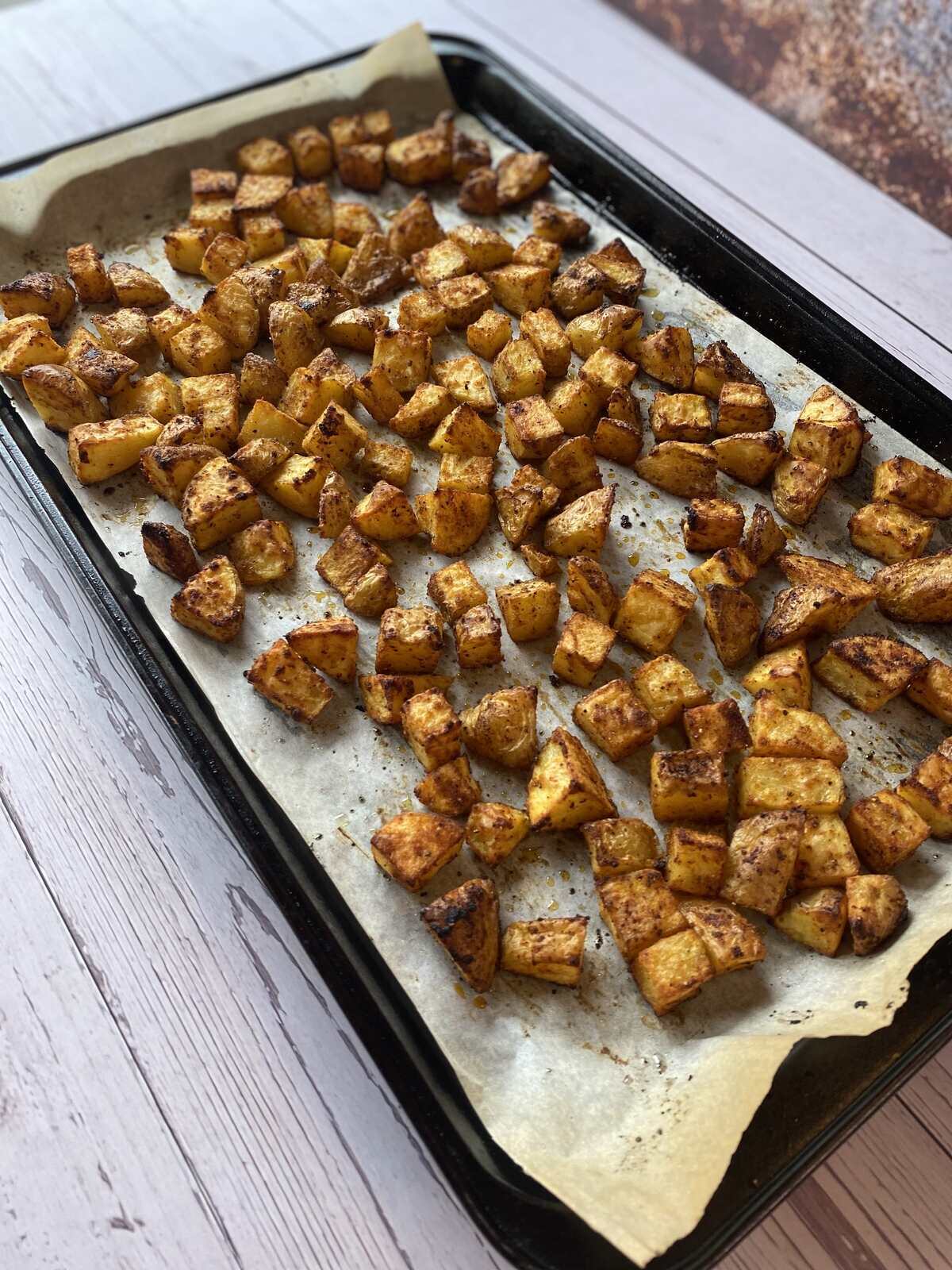 Seasoned and roasted potatoes on a sheetpan.