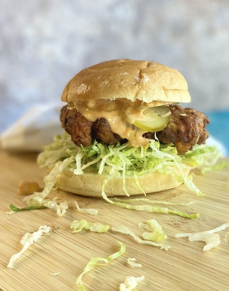 fried chicken sandwich with lettuce shreds falling off.