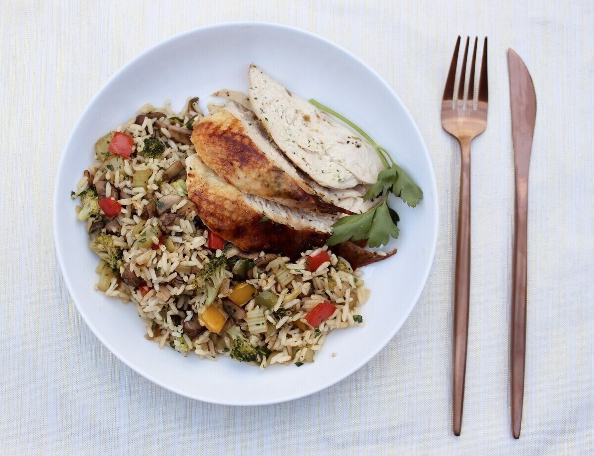 Garden vegetable rice with chicken on a table setting.