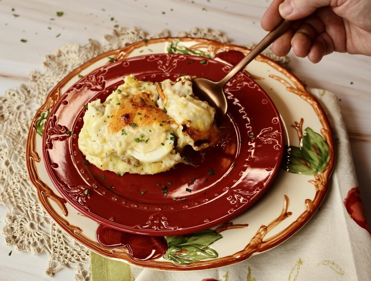 Spooning up a bite of anglesey eggs from a plate with a napkin.