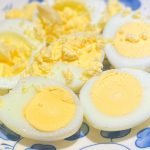 hardboiled eggs slice in half on a plate.