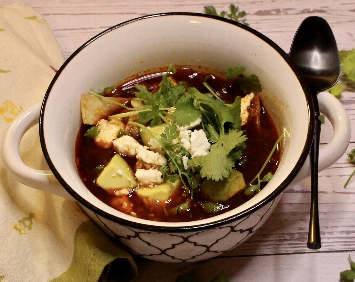 bowl of hearty chicken tortilla soup with a spoon.