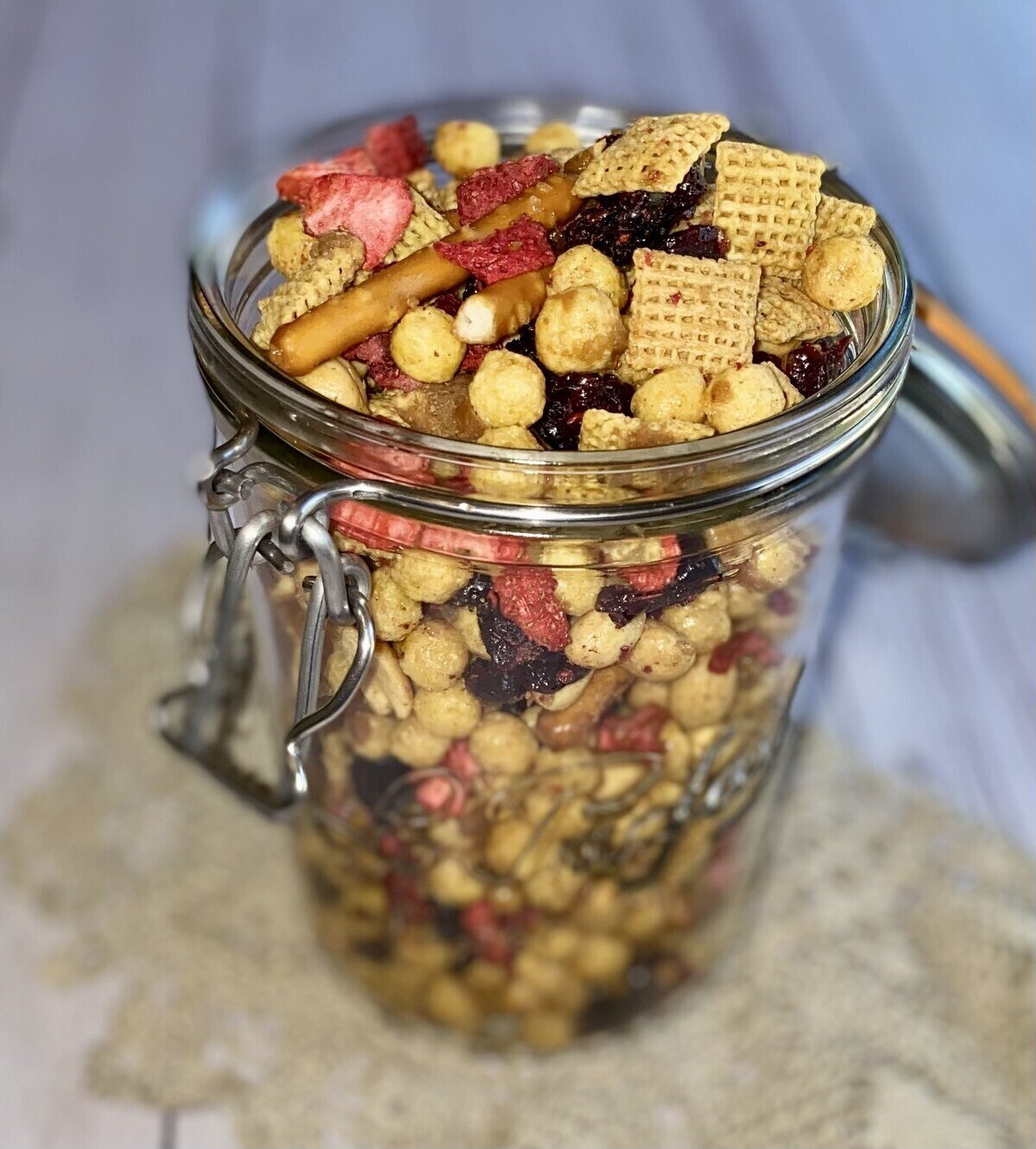 glass jar filled with sweet and salty PB&J snack mix.