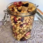 A large jar filled with pb&j snack mix.