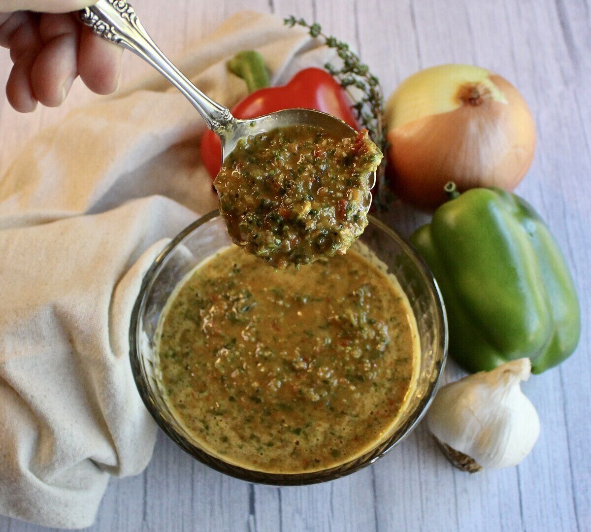 Bowl of haitian epis seasoning base with vegetables and a napkin.