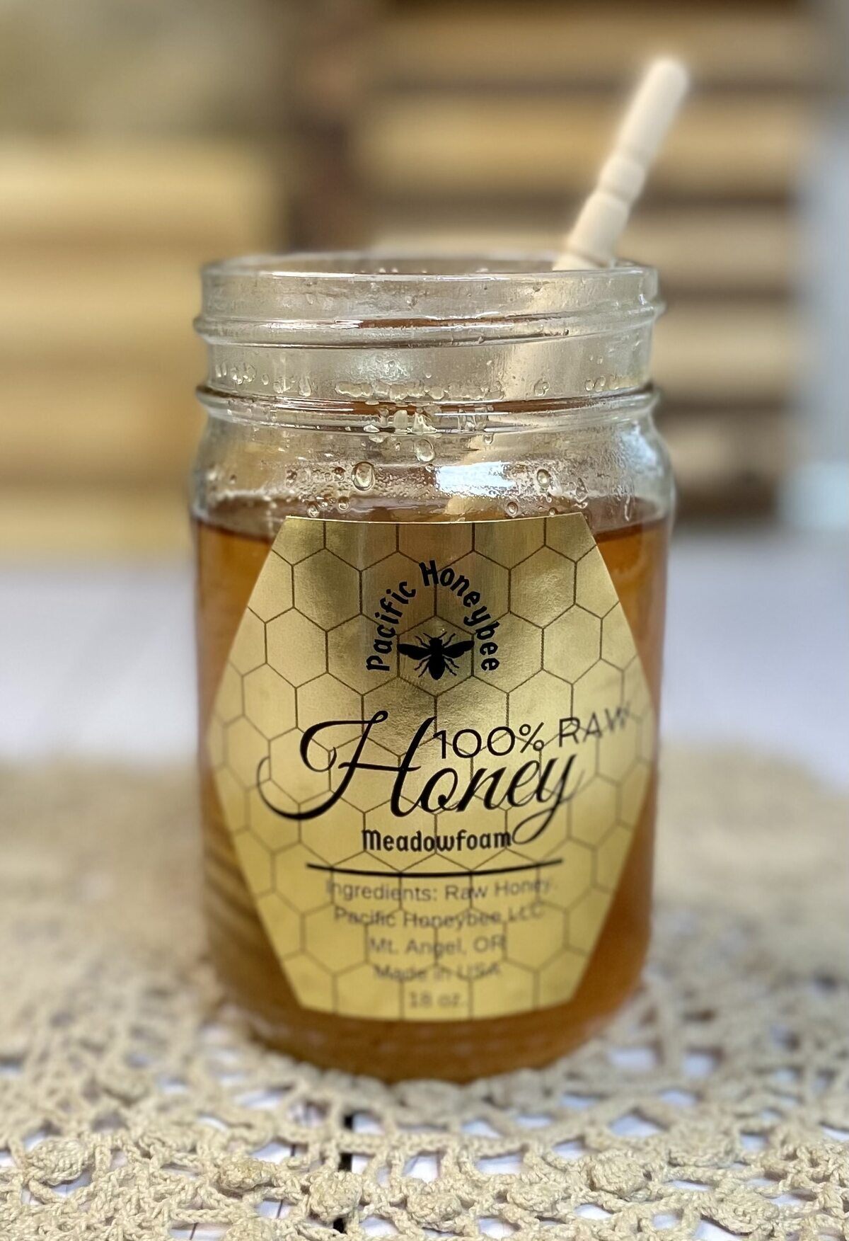 Jar of honey with a honey drizzle stick in it.