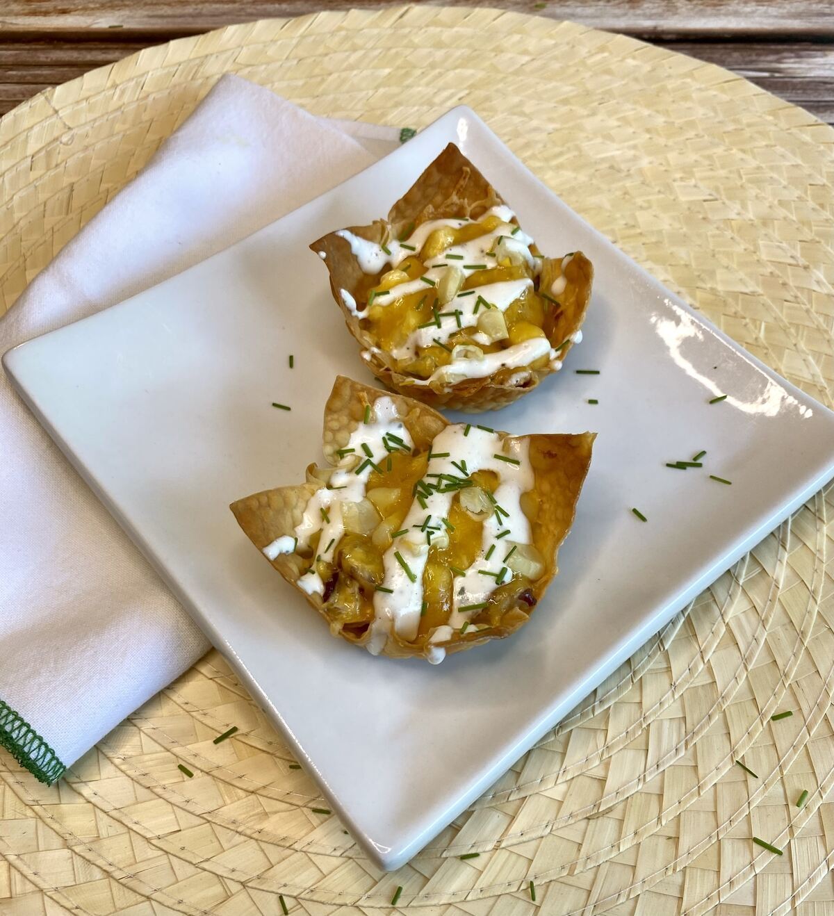 Two filled wonton cups on an appetizer plate with a napkin.