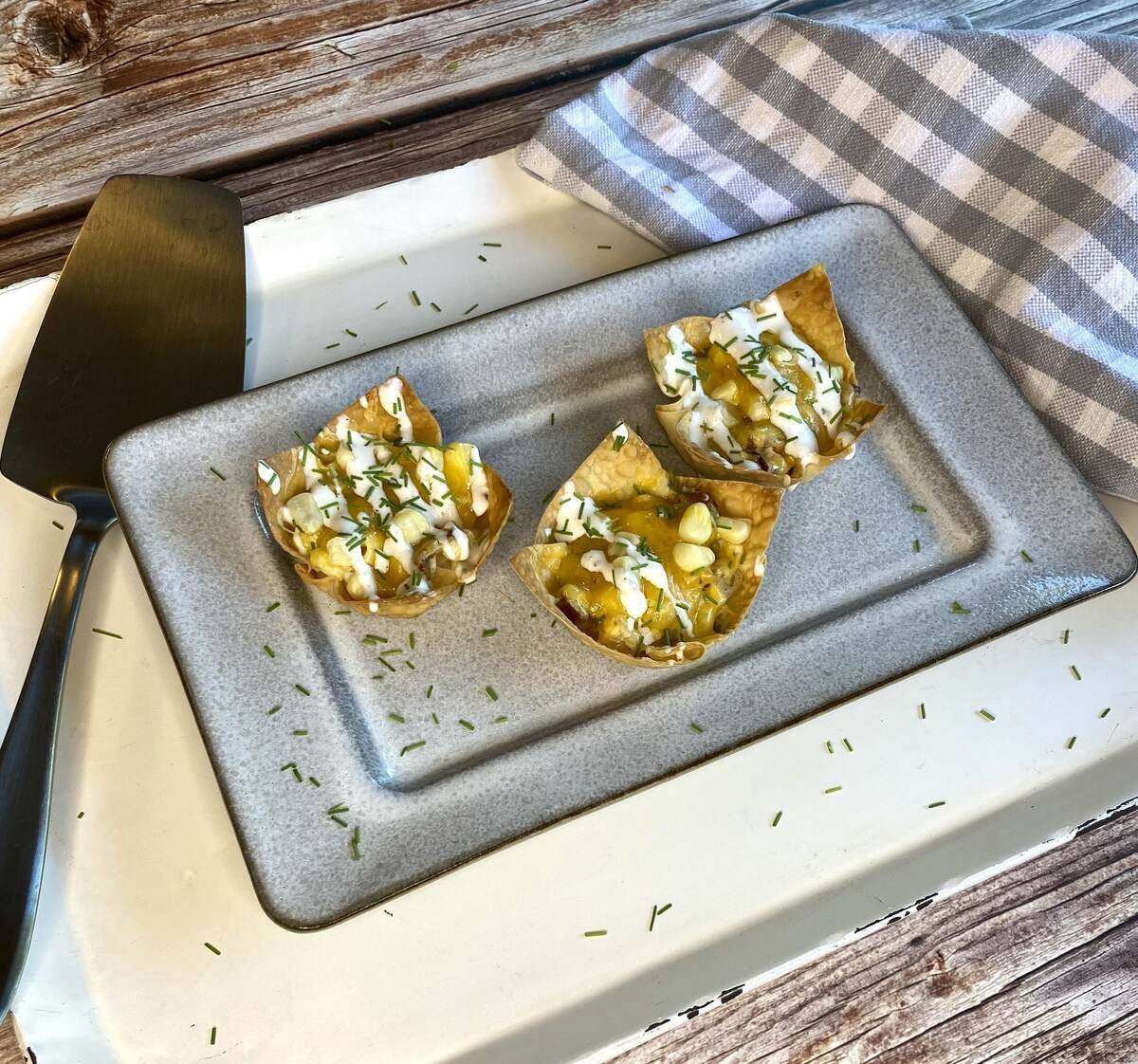 An appetizer plate with wontons, a server spatula, and a napkin.