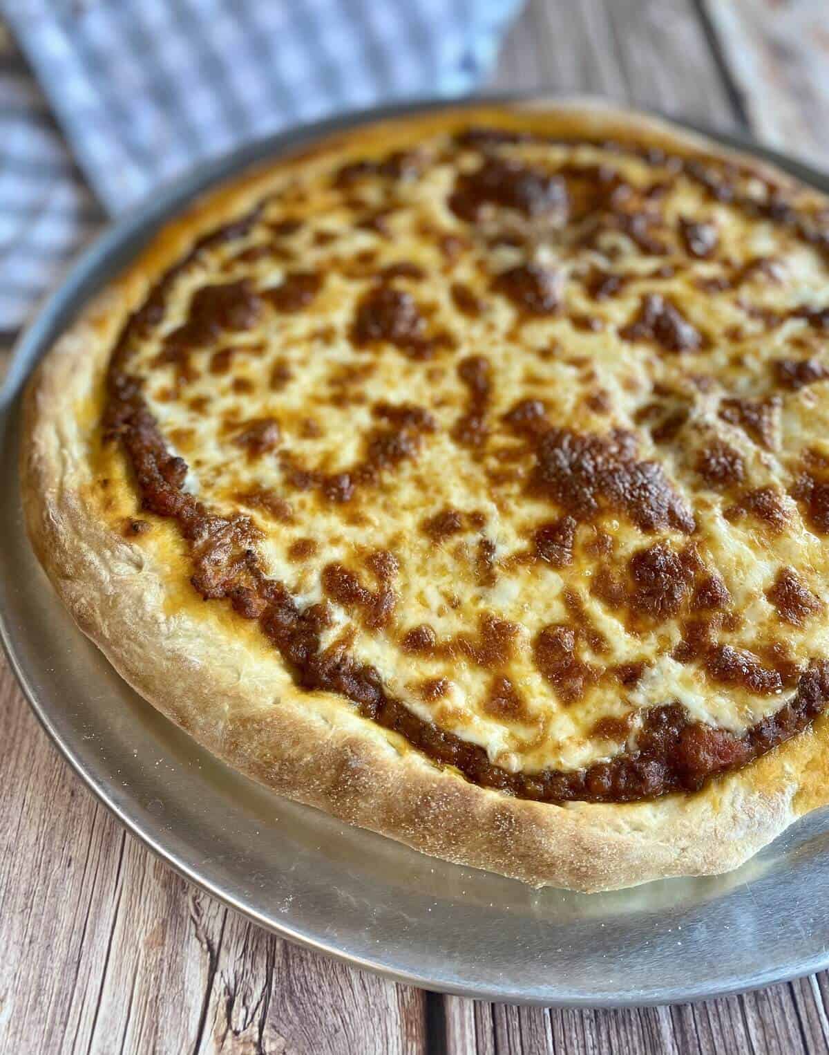 Closeup of bolognese pizza with a napkin.