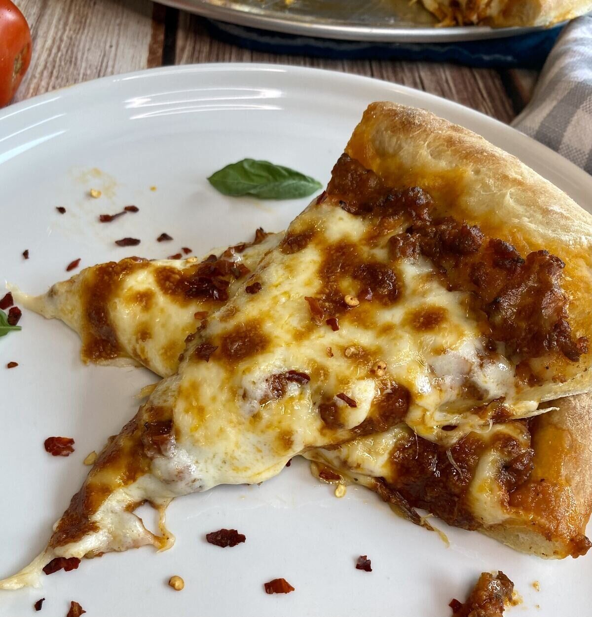 Slices of bolognese pizza on a plate.