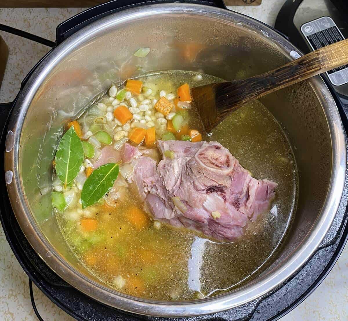 Adding the broth and hambone before starting the Instant Pot.