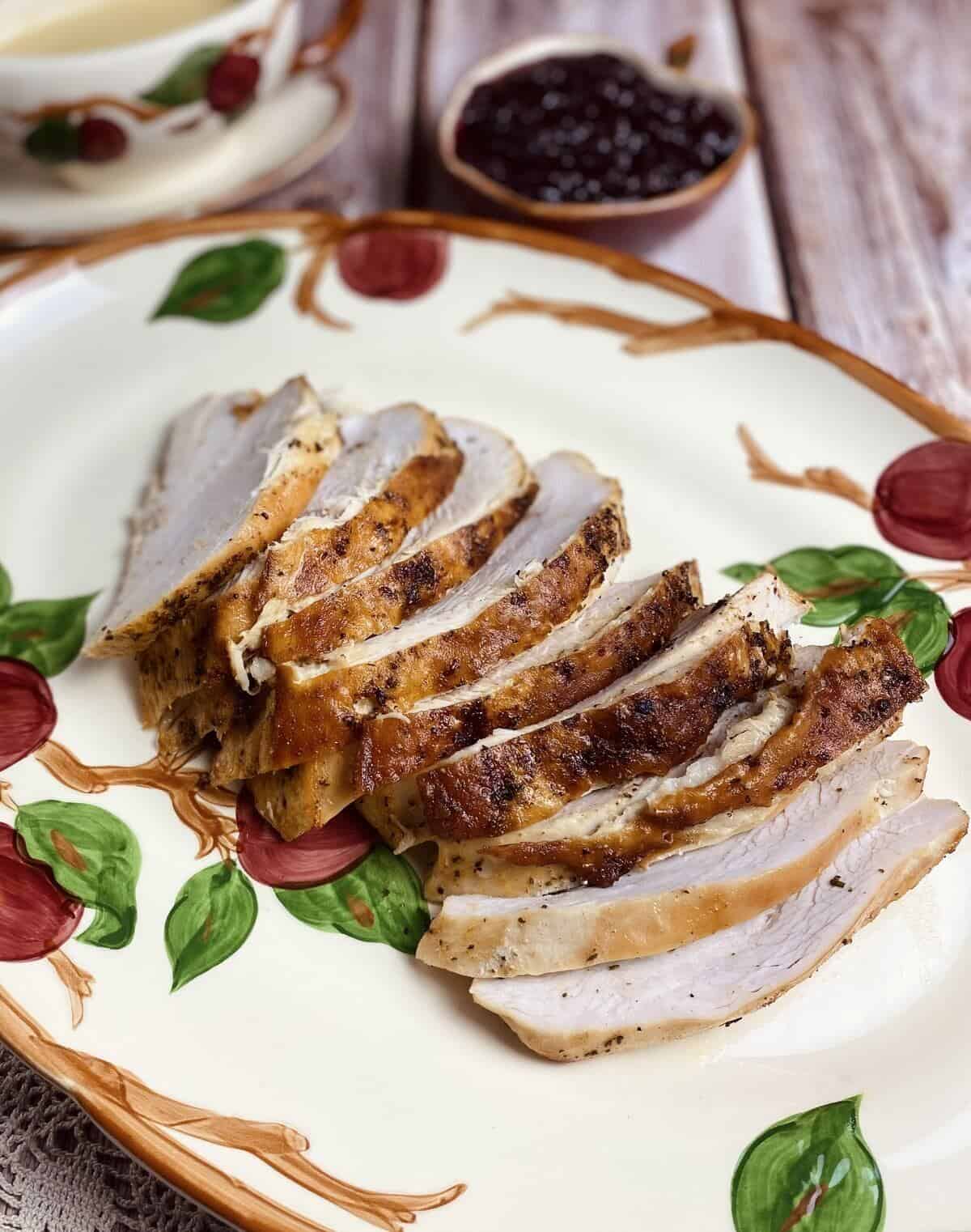 A roasted butterball turkey sliced thick and shingled on a serving platter.