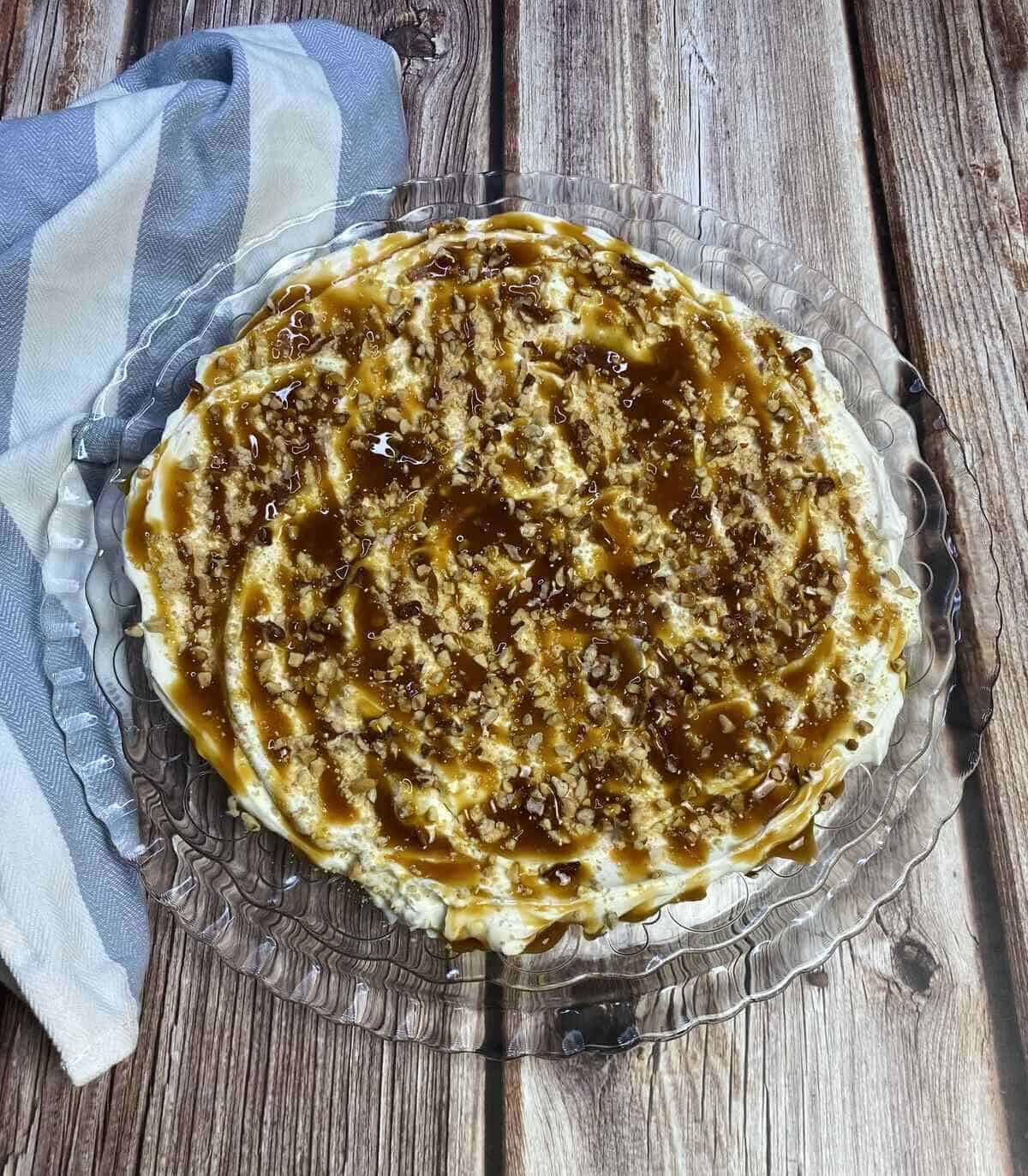 A platter with cheesecake dip and toppings with a napkin.