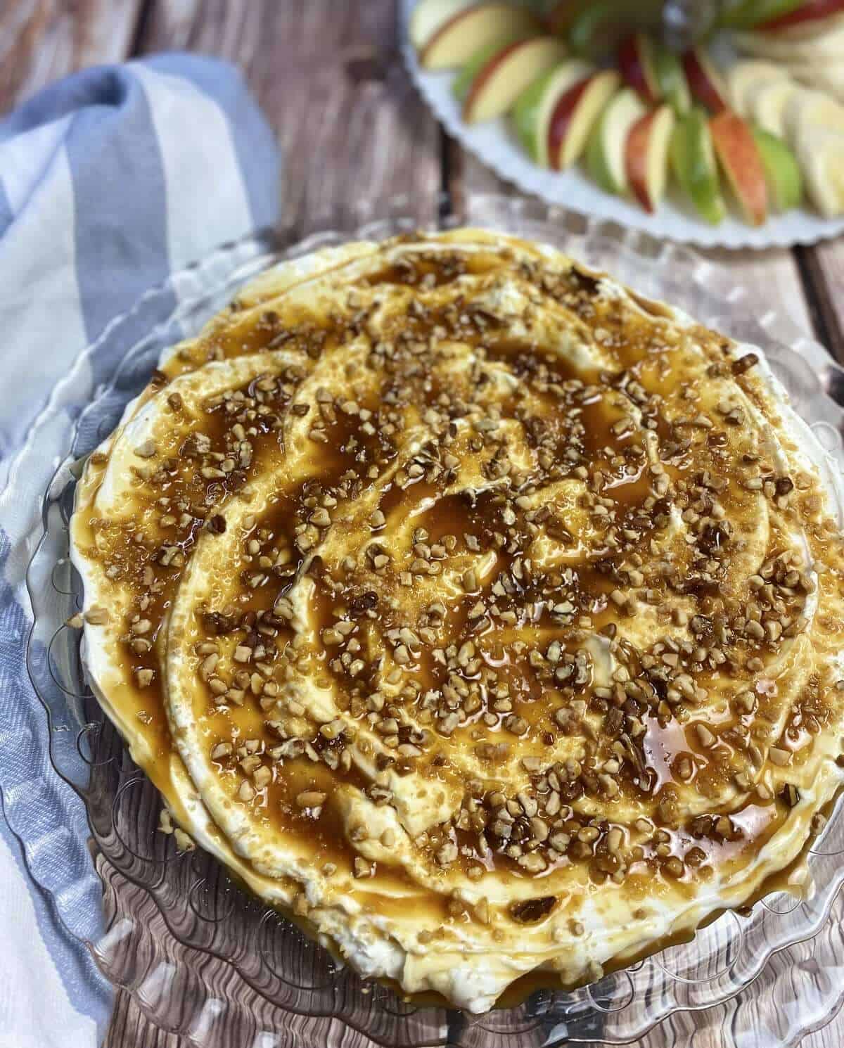 Cheesecake dip with sliced apples and a napkin.