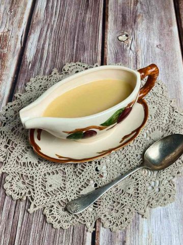 Feature photo for easy turkey gravy showing single gravy boat with spoon.