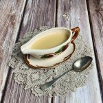 A gravy boat filled with easy turkey gravy along with a serving spoon.