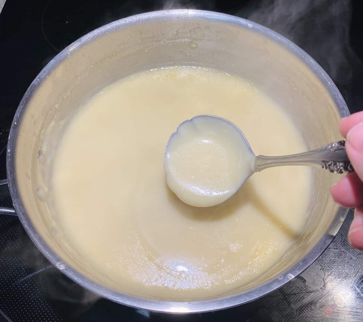 The gravy after it has thickened in a pot on the stove.