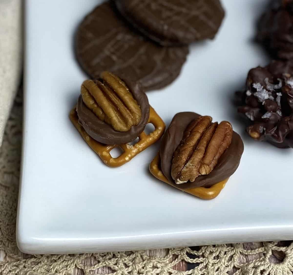 Rolo candy pecan turtle treats on a white plate.