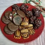 Three easy christmas treats on a red plate with candy canes alongside.