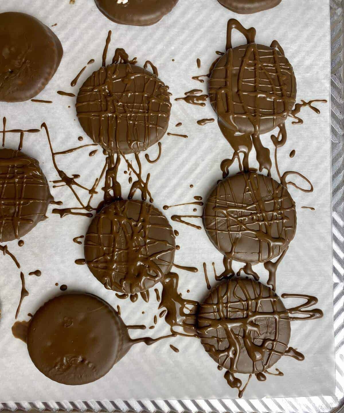 Andes chocolate covered ritz crackers on parchment after they've cooled and had more chocolate drizzled on top for texture.