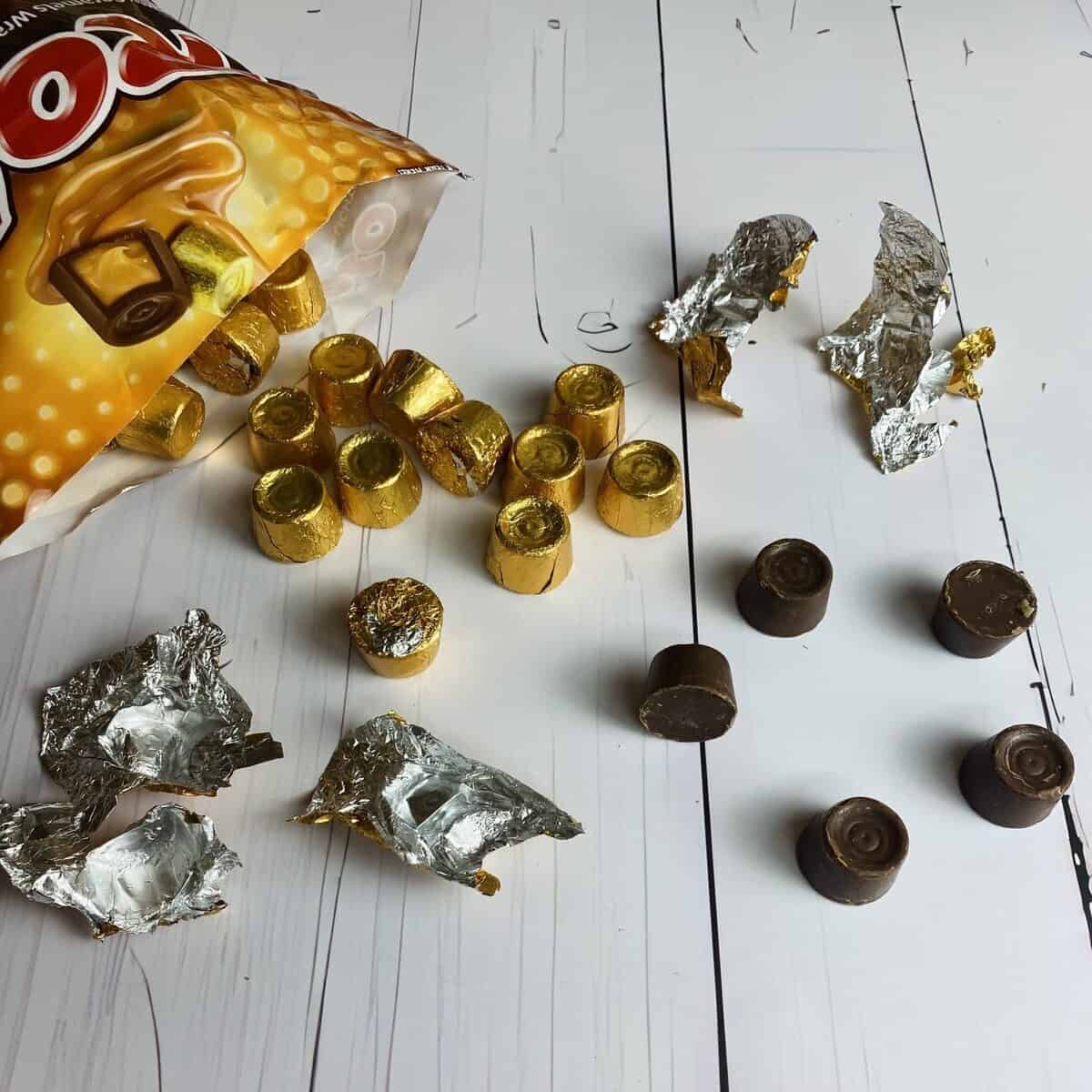 Rolo candies falling out of the package with some unwrapped from the foil.