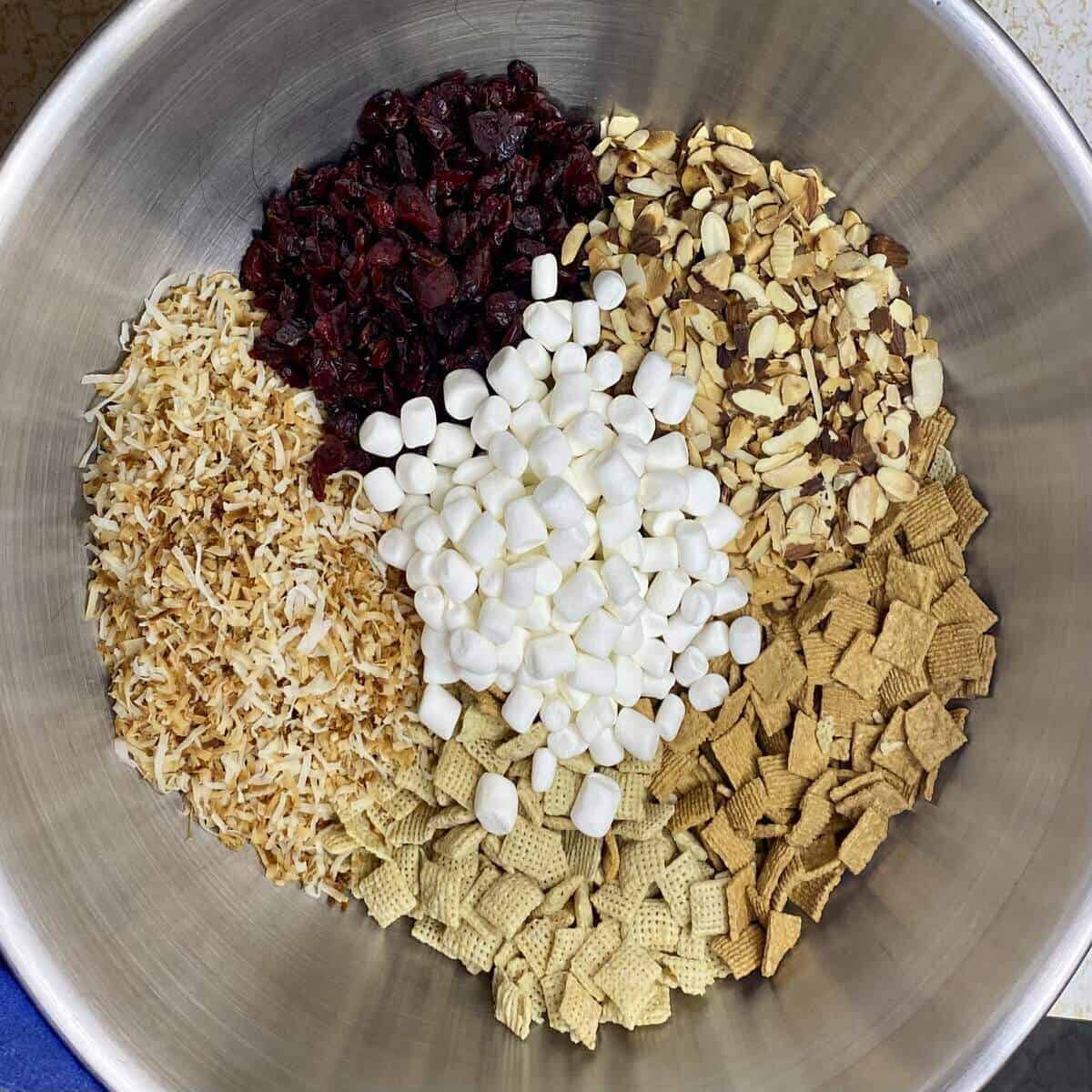 A very large stainless steel bowl containing all the dry ingredients for the recipe.