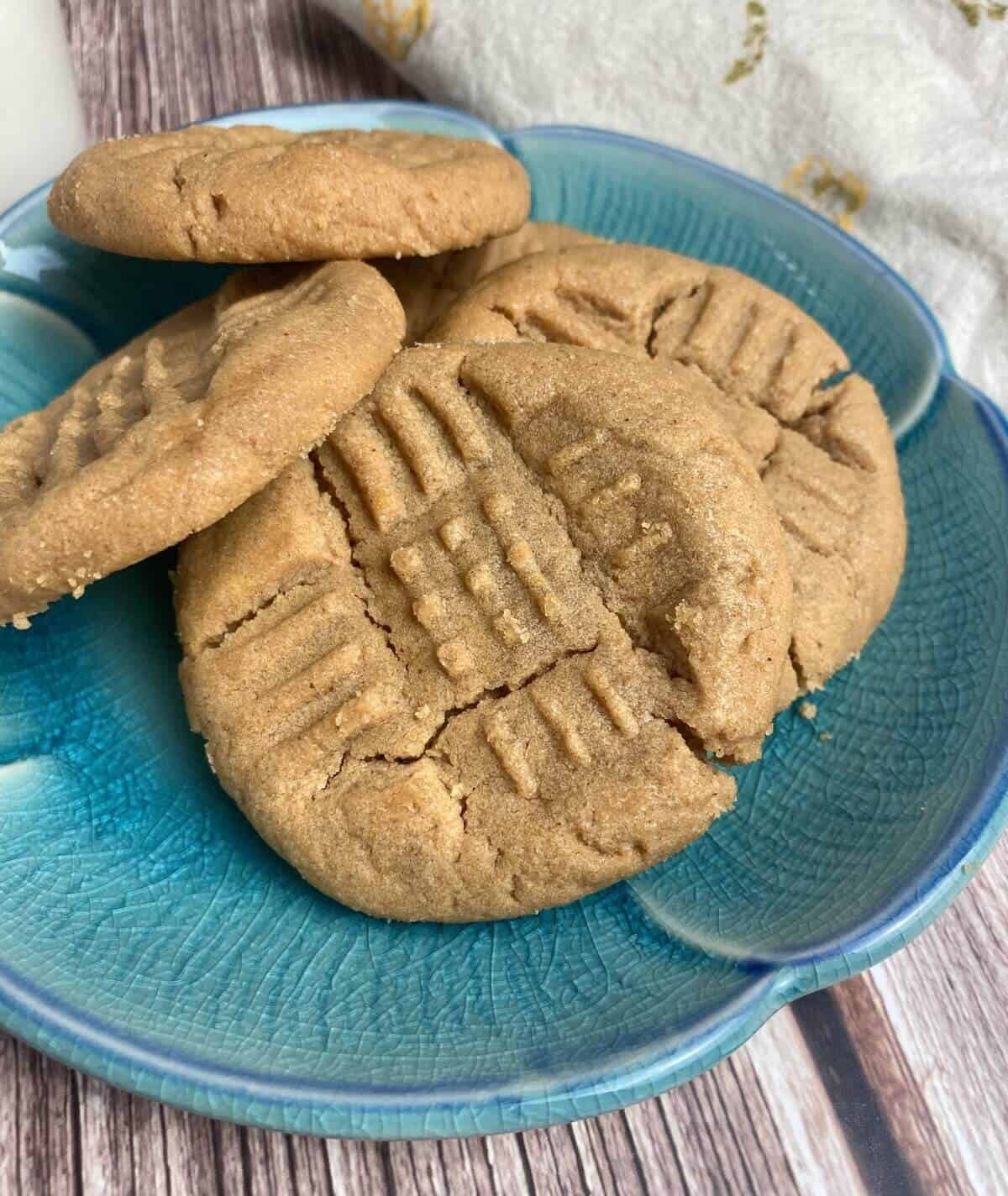 A closeup of peanut butter cookies on a blue plate.