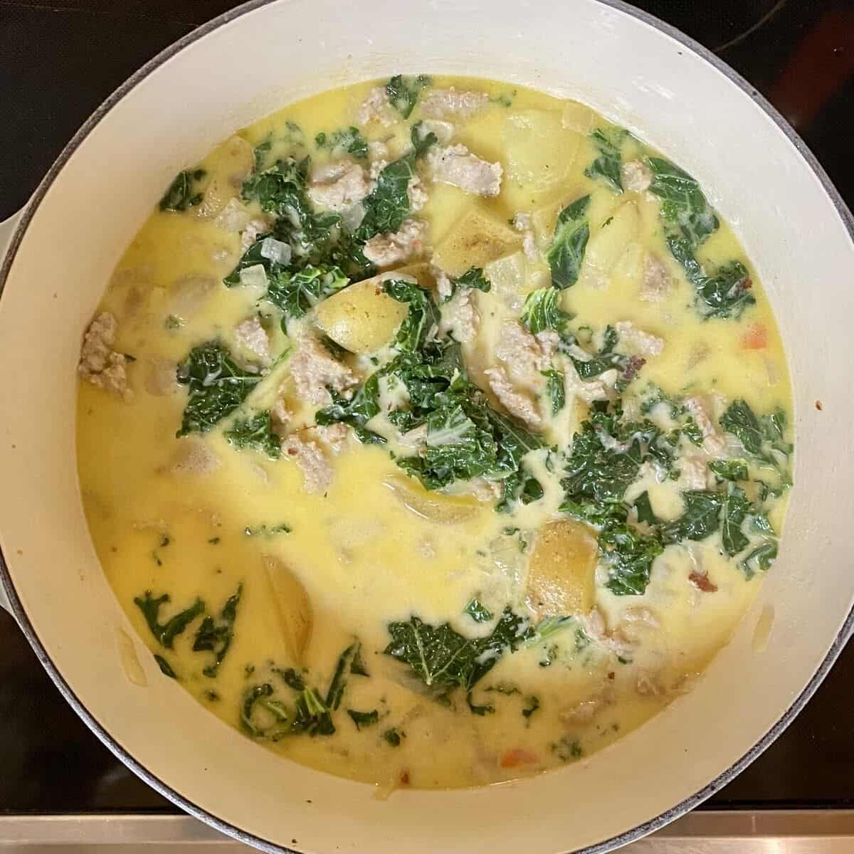 A large pot on the stove with all the ingredients simmering in broth.