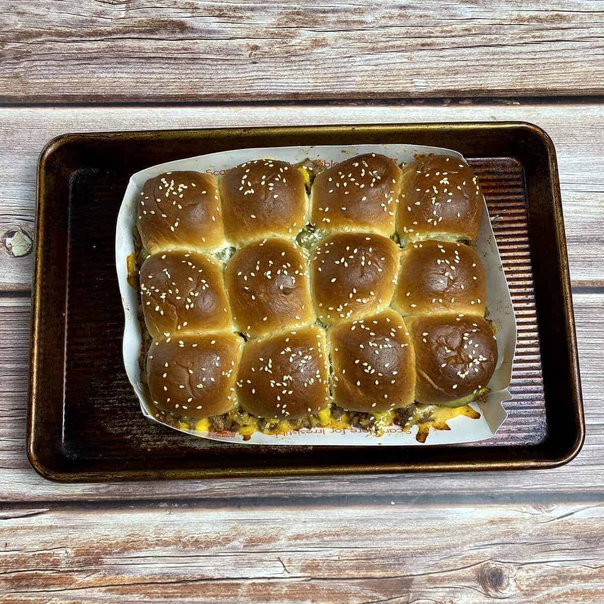 A baked tray of sliders on a sheetpan.