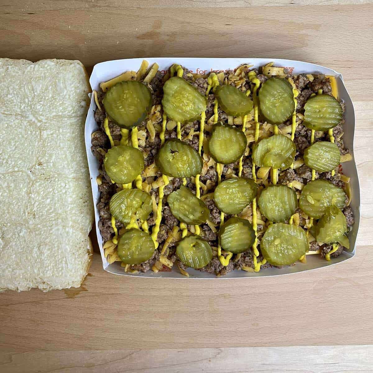 The bottom half of the rolls with all the ingredients layered on top alongside the top half of the rolls.