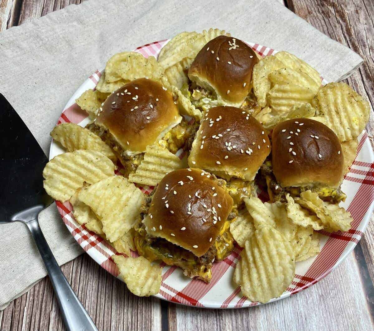 Cheeseburger sliders on a plate with potato chips.