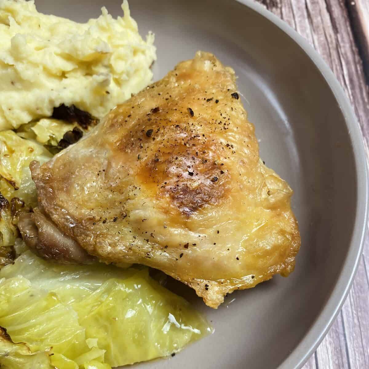 A crispy chicken thigh on a plate.