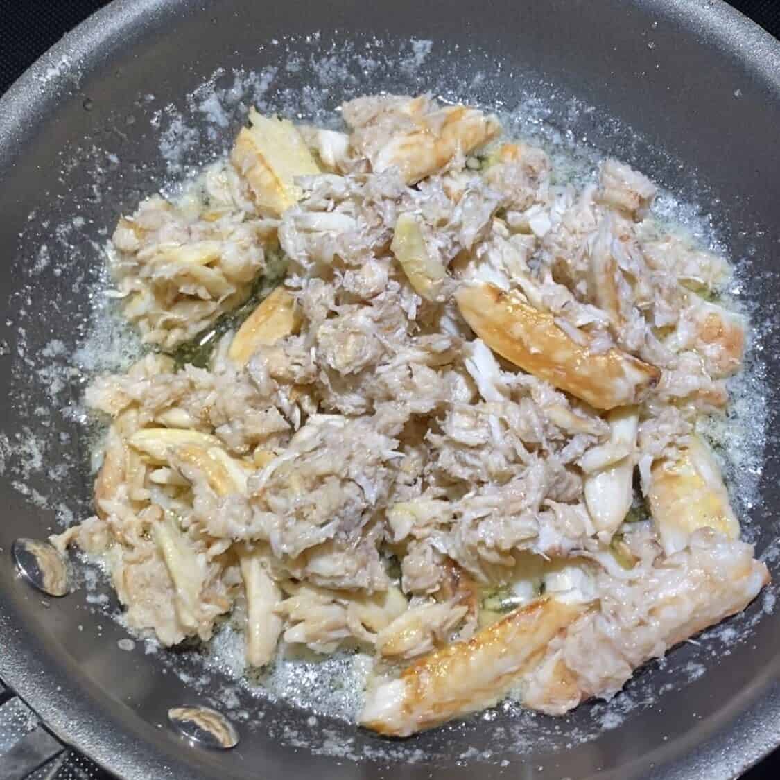 Fresh crab put into a pan with butter and garlic.