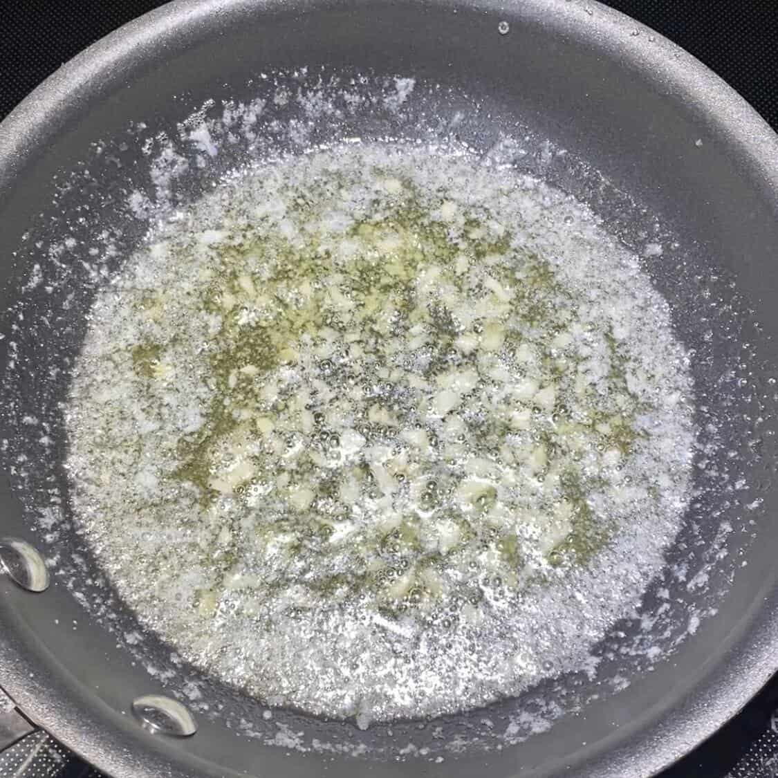 A pan with melted butter and garlic.