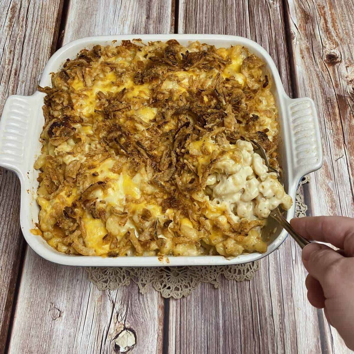 The guinness mac & cheese bake and being served with a spoon.