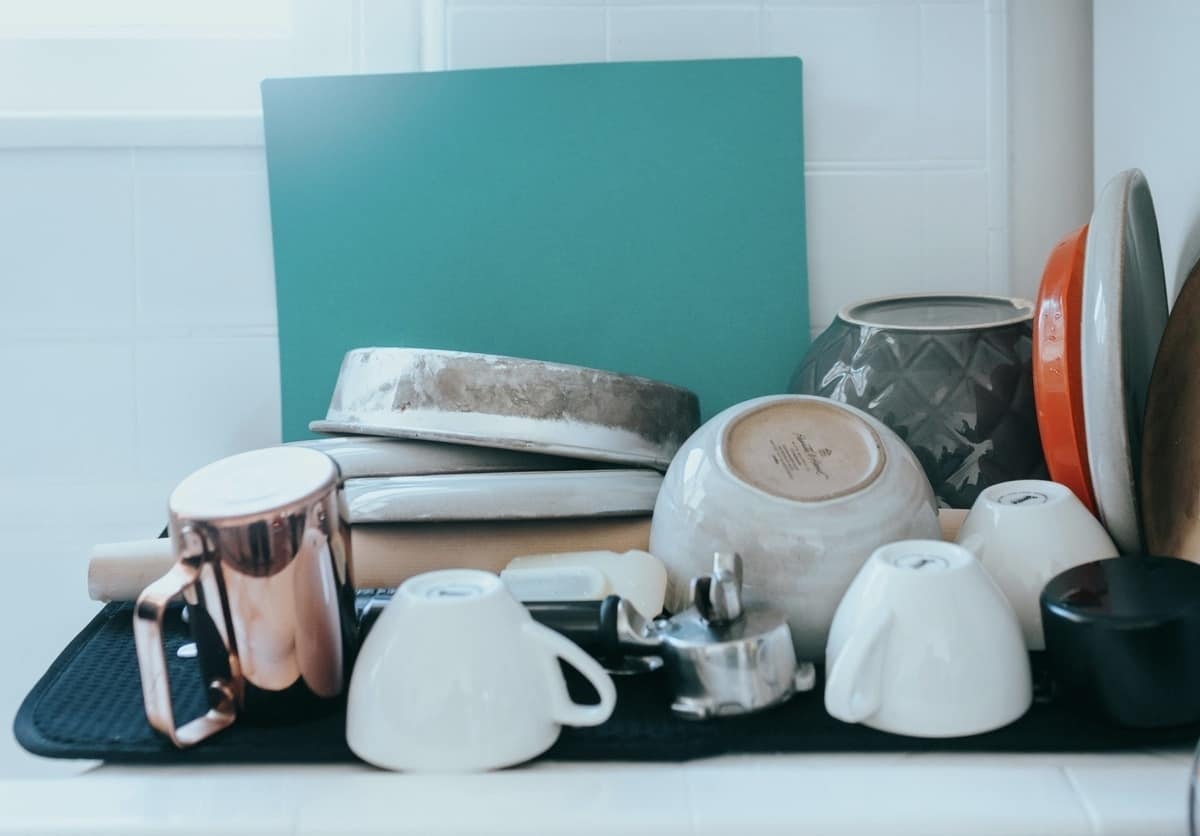 Several bowls and cooking dishes set upside down on a drying pad after cleaning.