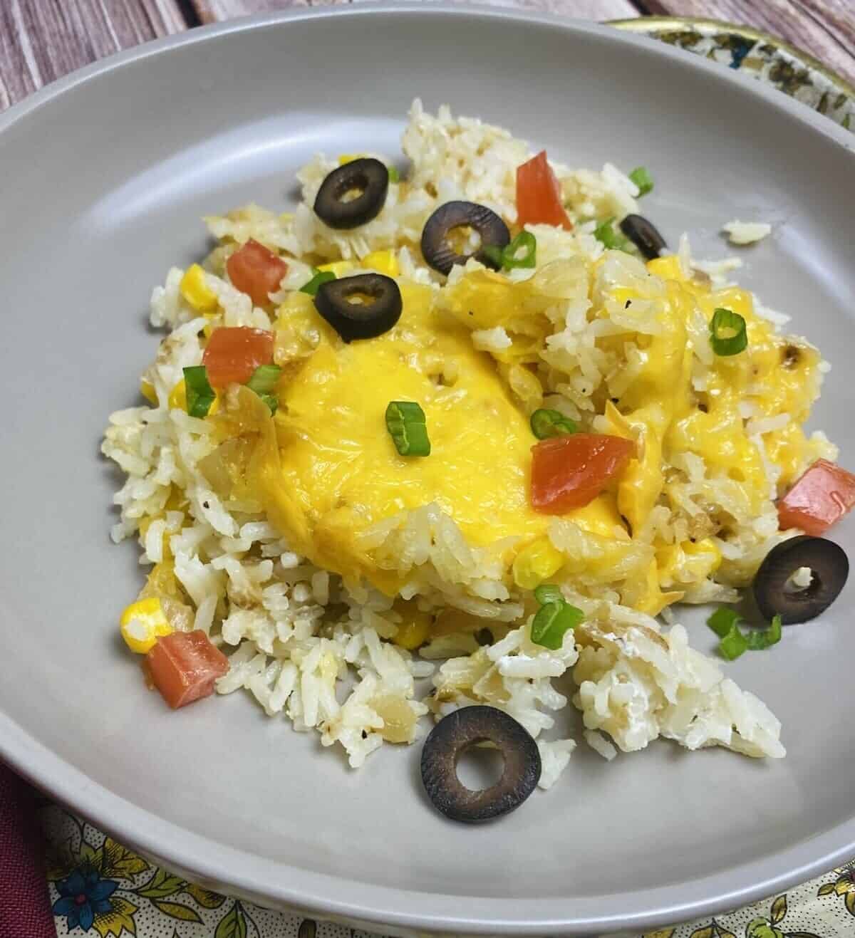 A serving of sour cream rice on a plate with extra toppings.