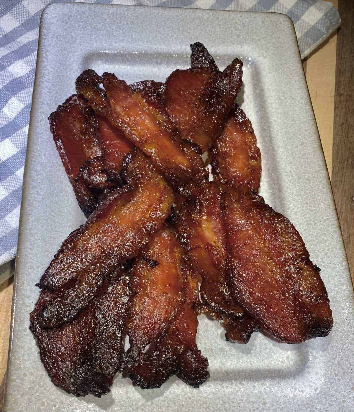 A plate filled with maple bacon and a napkin.