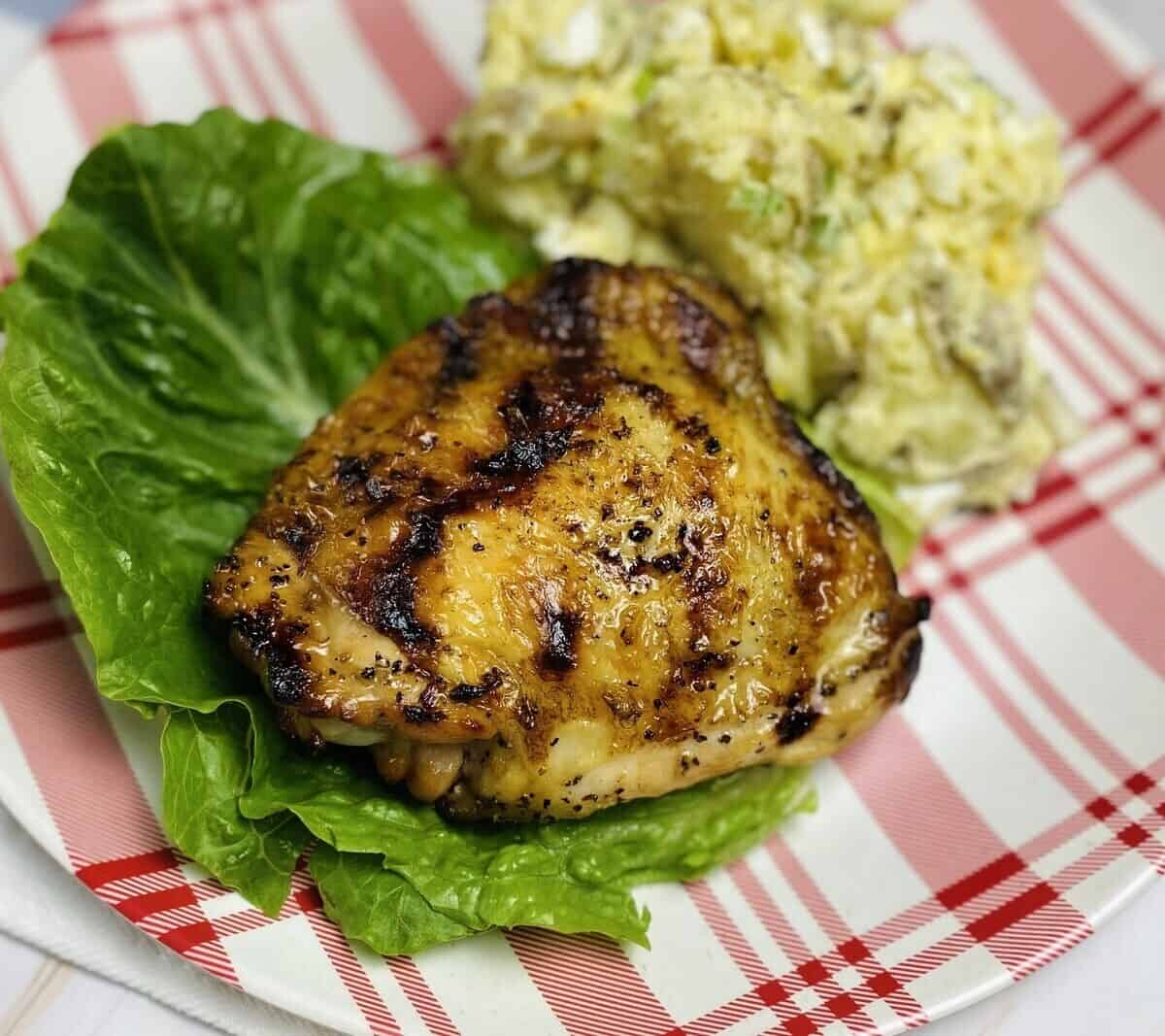 Mesquite grilled chicken on a plate with potato salad.