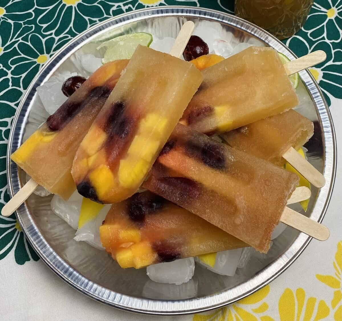 Several white sangria popsicles piled on an ice tray.