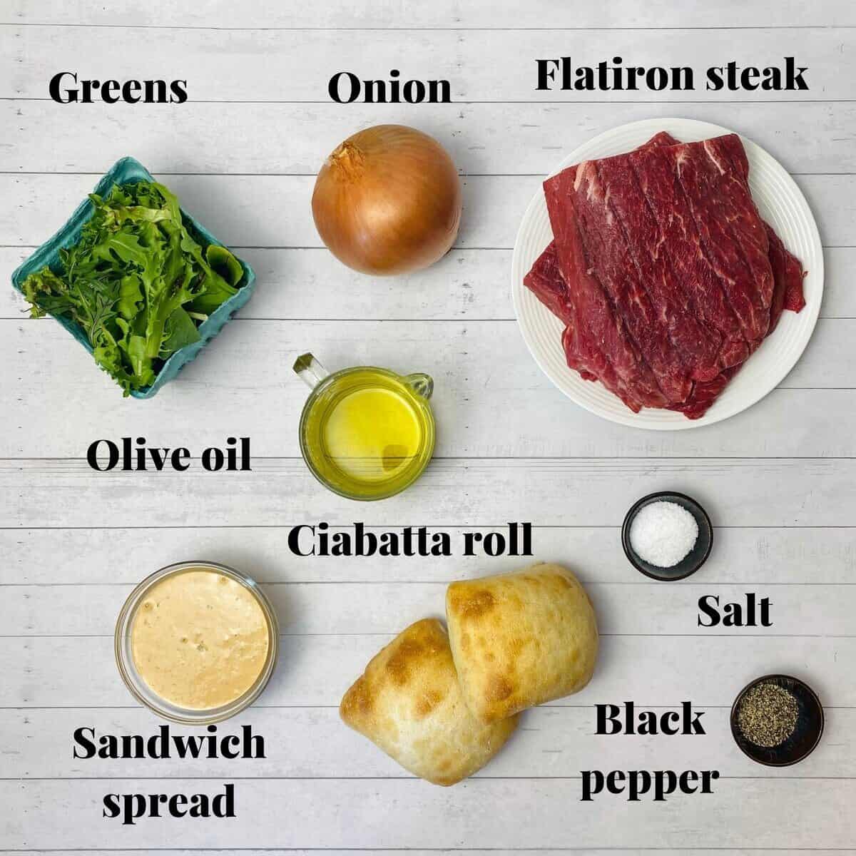 All the ingredients needed to make a flatiron steak sandwich with griddled onions.