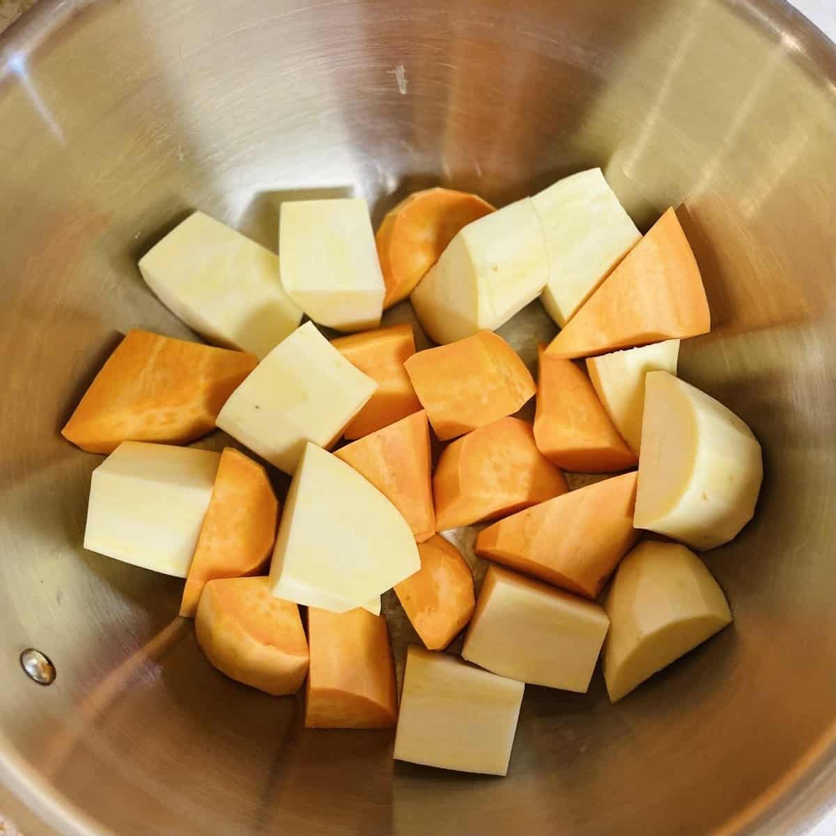 Silver bowl with diced yams and sweet potatoes.