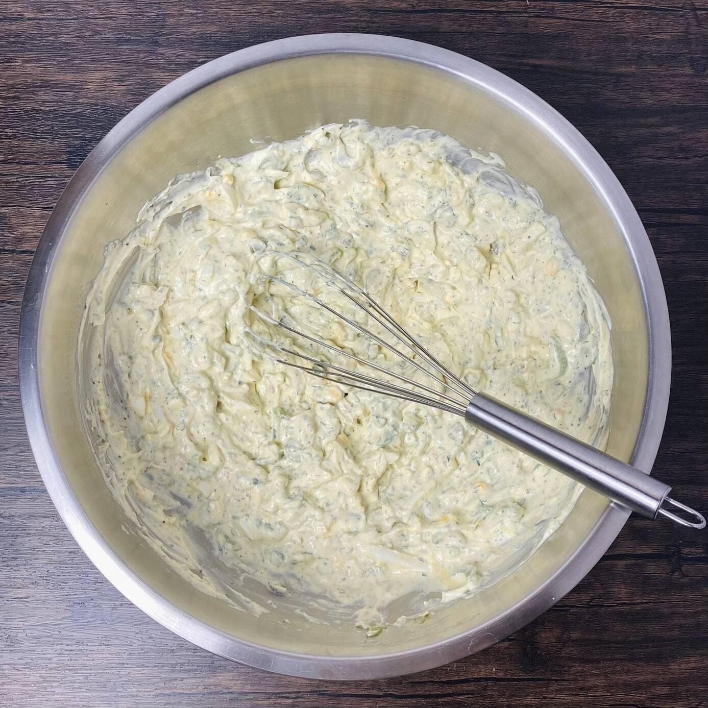 Potato salad dressing ingredients mixed up with a whisk.