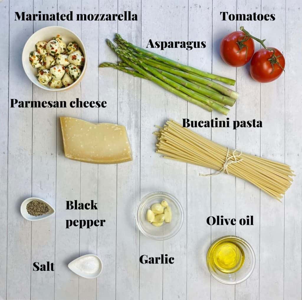 All the ingredients needed to make asparagus and tomato pasta.