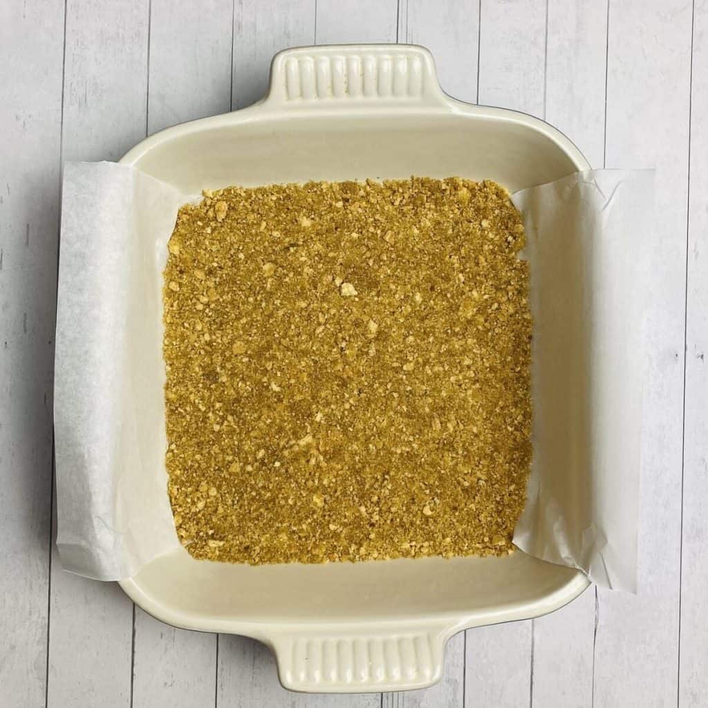 A dish with buttery graham cracker crumbs pressed into the bottom.